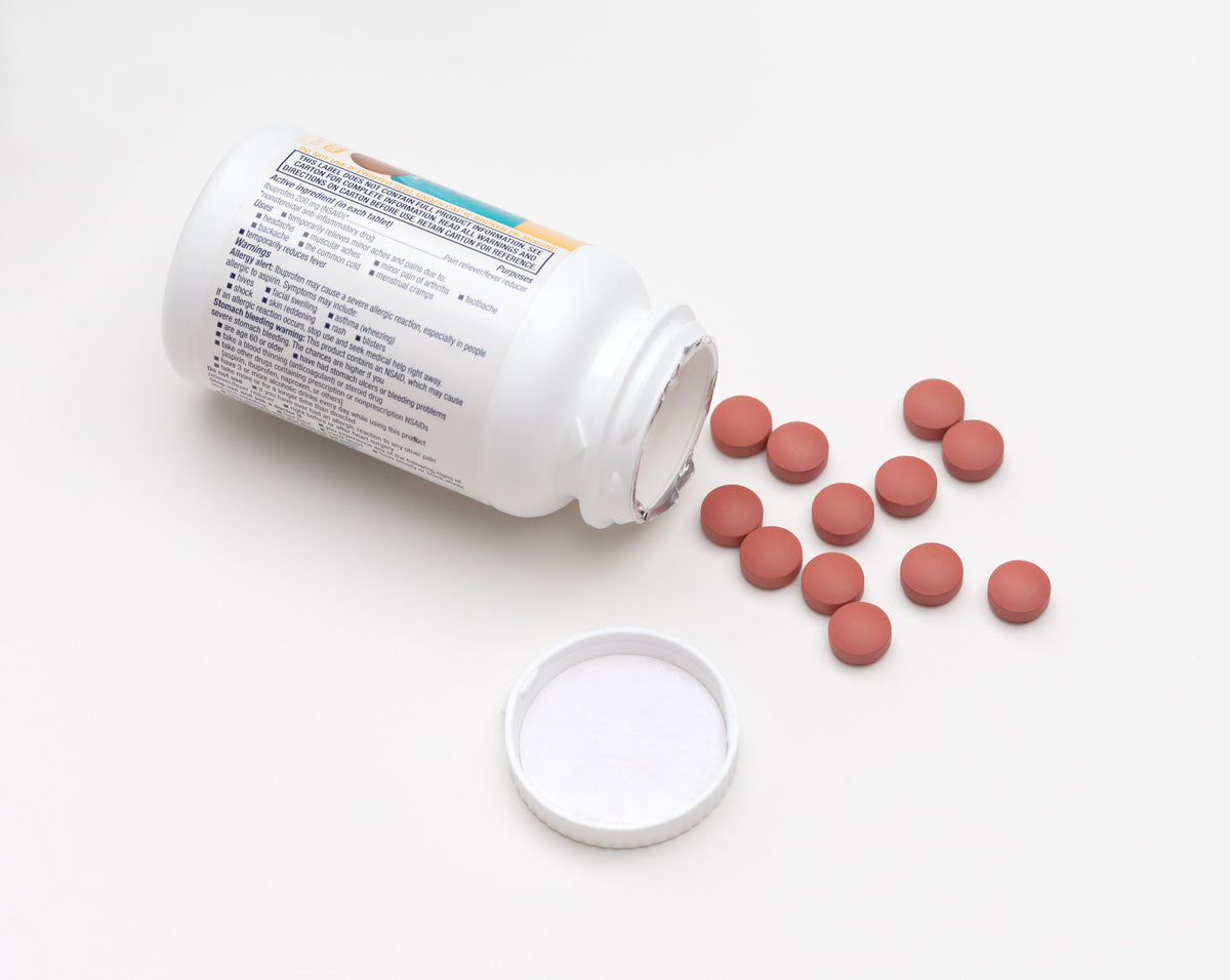 Ibuprofen tablets spilling from the bottle