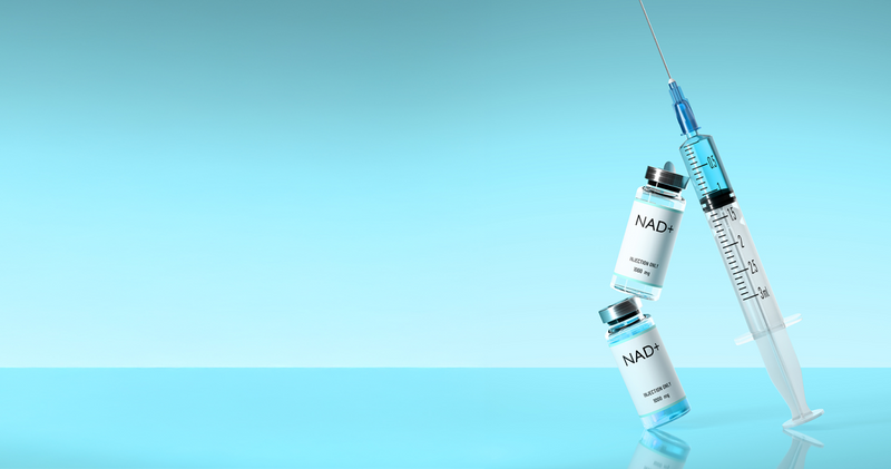 Two NAD+ 1000mg injection vials alongside a medical syringe on a reflective light blue surface.