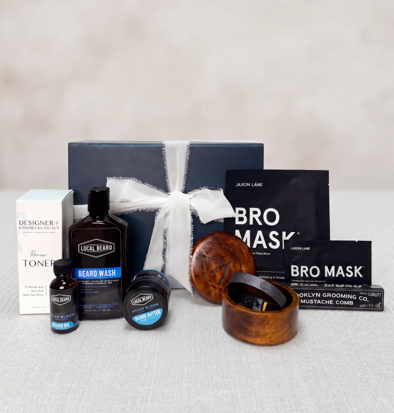 Father's Day collection of grooming products including bottles, masks, and a box on a neutral background