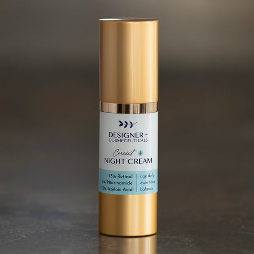 Designer+ Cosmeceuticals Correct+ Night Cream with 1.5% retinol, 4% niacinamide, and 15% azelaic acid in a gold and white airless pump bottle, on a reflective surface with a dark background