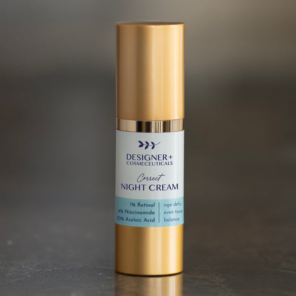 Designer+ Cosmeceuticals Correct Night Cream with 1% retinol, 4% niacinamide, and 10% azelaic acid in a gold and white airless pump bottle, on a reflective surface with a dark background
